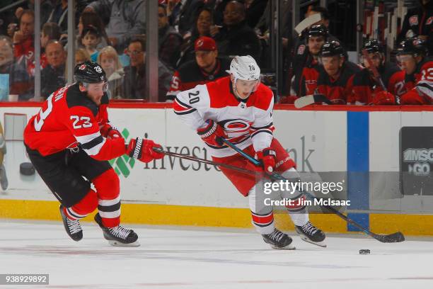 Sebastian Aho of the Carolina Hurricanes plays the puck against Stefan Noesen of the New Jersey Devils in the second period during the game on March...