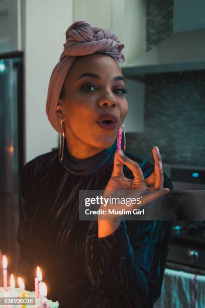 a muslim hostess blowing out the candle - smirk stock pictures, royalty-free photos & images