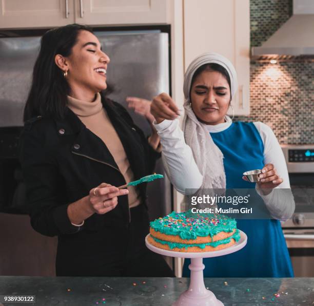muslim girl "sprinkle bae" and her best friend, adding sprinkles onto a cake - party host stock photos et images de collection