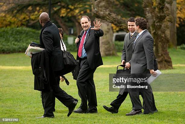David Axelrod, senior advisor to U.S. President Barack Obama, center, waves while walking on the South Lawn of the White House to board Marine One...