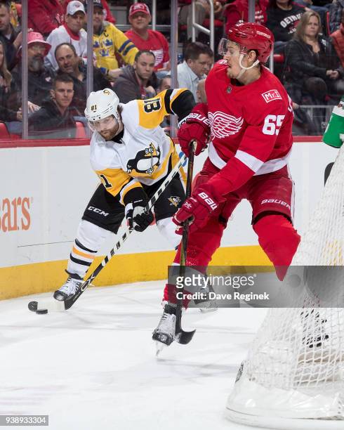 Phil Kessel of the Pittsburgh Penguins handles the puck behind the net in front of Danny DeKeyser of the Detroit Red Wings during an NHL game at...