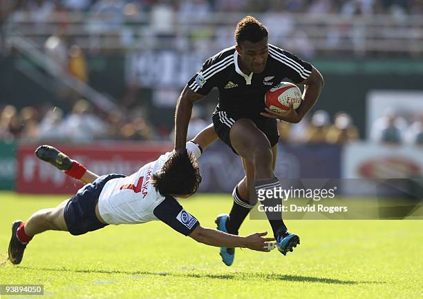 Save Tokula of New Zealand moves away from Nicolas Kraska of France to score a try during the IRB Sevens tournament at the Dubai Sevens Stadium on...