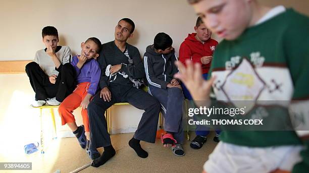Disabled and orphaned Romanian children hang around in a room on November 24 at the Targu Jiu orphanage, southwestern Romania, after being transfered...
