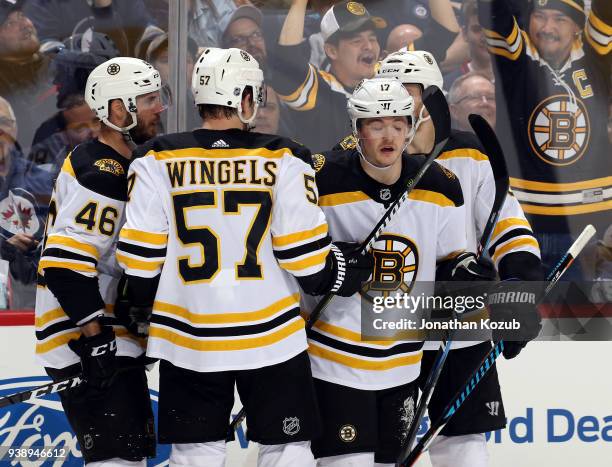 David Krejci, Tommy Wingels, Ryan Donato and Kevan Miller of the Boston Bruins celebrate a first period goal against the Winnipeg Jets at the Bell...