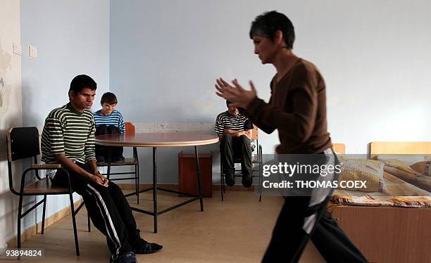 Disabled and orphaned Romanian adults hang around in a room on November 25 at the Targu Jiu orphanage, southwestern Romania, after being transfered...