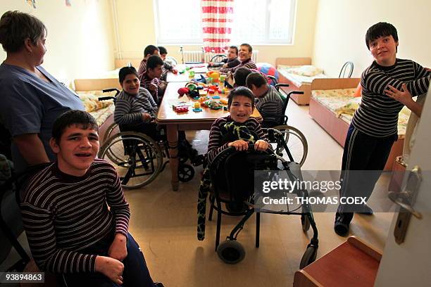 Disabled and orphaned Romanian adults play on November 25 at the Targu Jiu orphanage, southwestern Romania, after being transfered from Bilteni's...