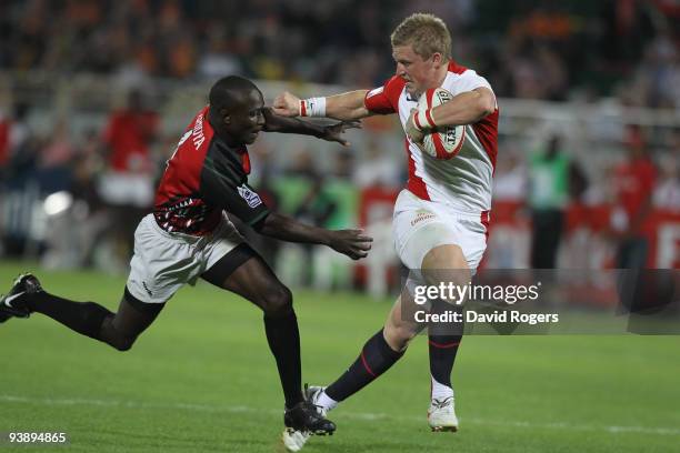 Jake Abbott of England holds off Sidney Ashioya of Kenya to score a try during the IRB Sevens tournament at the Dubai Sevens Stadium on December 4,...