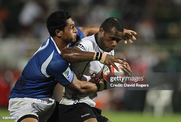 Waisoni Votu of Fiji is held by Alafoti Fa'osiliva of Samoa during the IRB Sevens tournament at the Dubai Sevens Stadium on December 4, 2009 in...