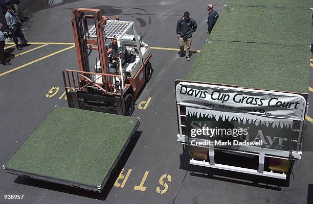 StrathAyr staff remove portions of the portable grass court to be used for the Davis Cup Final against France, from a truck bed to the centre court...