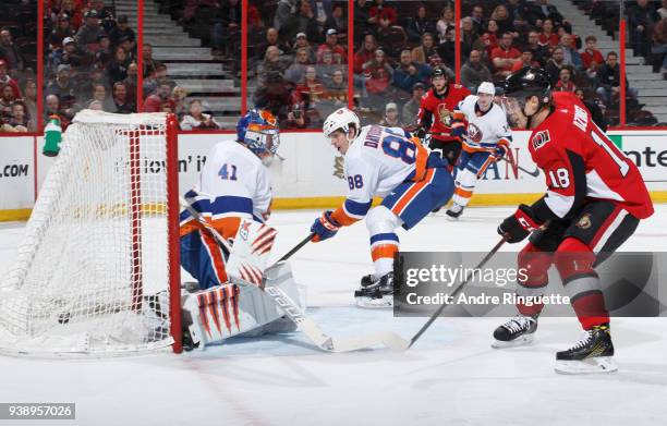 Brandon Davidson of the New York Islanders deflects the puck past teammate aroslav Halak for an own-goal that would be attributed to Bobby Ryan of...