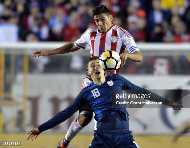 Fabian Balbuena of Paraguay battles Andrija Novakovich of United States for a header during their game at WakeMed Soccer Park on March 27, 2018 in...