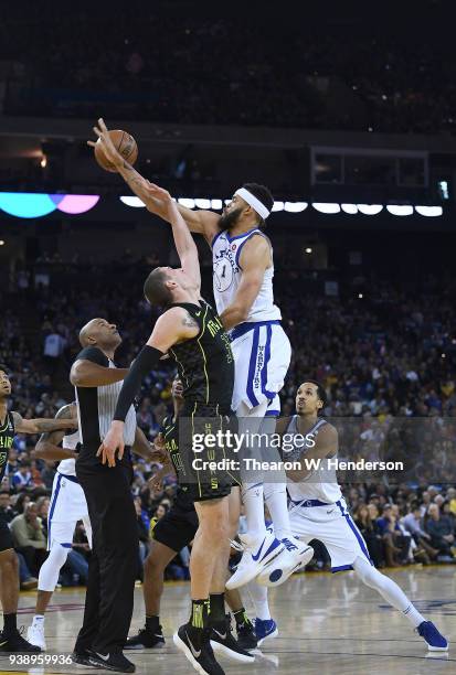 JaVale McGee of the Golden State Warriors battles for a jump-ball with Mike Muscala of the Atlanta Hawks during an NBA basketball game at ORACLE...