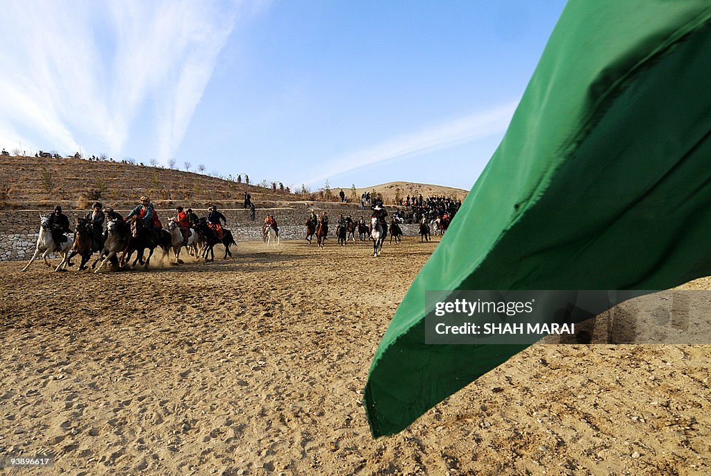 Afghan horsemen compete for a calf durin