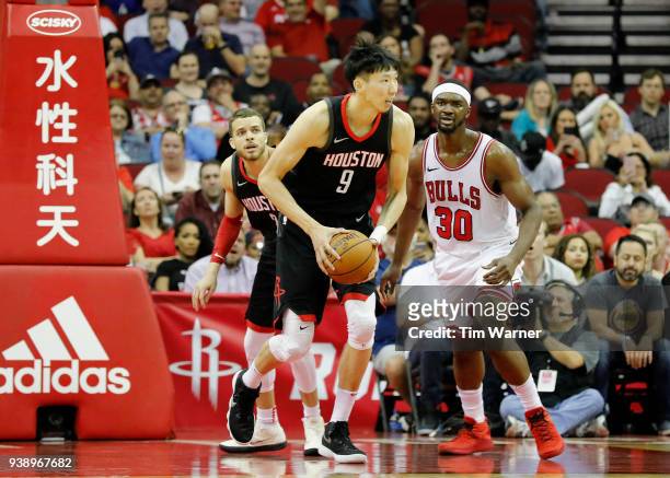 Zhou Qi of the Houston Rockets grabs a rebound in the second half defended by Noah Vonleh of the Chicago Bulls at Toyota Center on March 27, 2018 in...