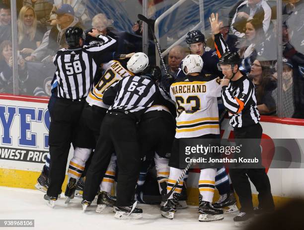 Linesman Ryan Gibbons and Brandon Gawryletz try to separate Winnipeg Jets and Boston Bruins players during a second period scrum at the Bell MTS...