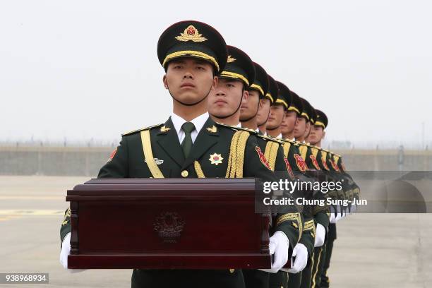 Chinese soldiers carry caskets containing the remains of Chinese soldiers during the handing over ceremony at the Incheon International Airport on...