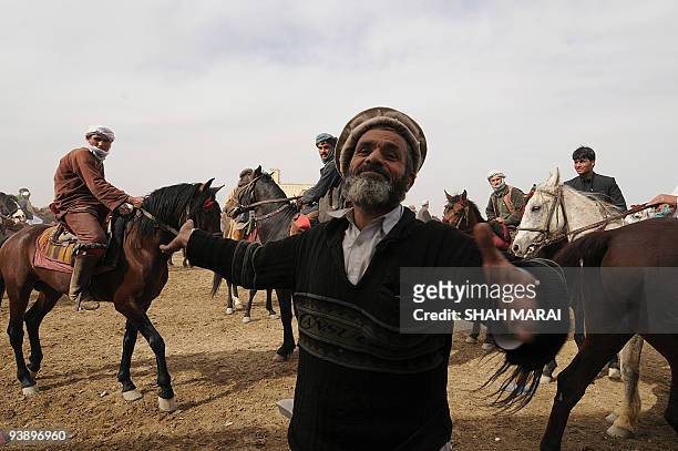 An Afghan man dances during Afghanistan's traditional game of Buzkashi in the northern town of Mazar-i-Sharif on March 21, 2009. Buzkashi which has...