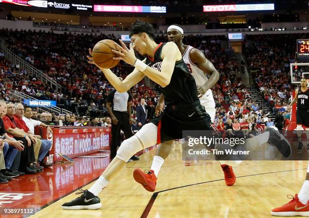 Zhou Qi of the Houston Rockets controls a loose ball defended by Noah Vonleh of the Chicago Bulls in the second half at Toyota Center on March 27,...
