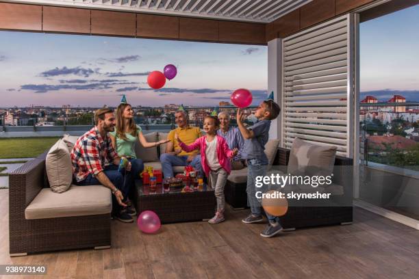 familia feliz divertirse durante la fiesta de cumpleaños en un patio de penthouse. - penthouse girl fotografías e imágenes de stock