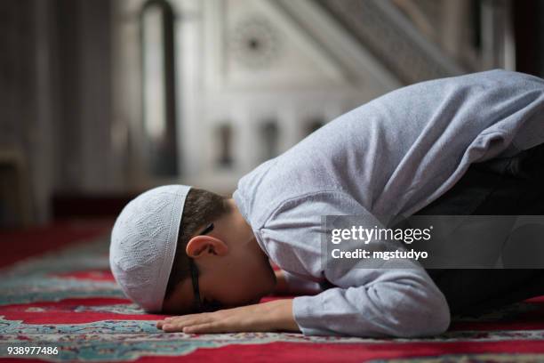 muslim boy praying in mosque - ramadan prayer stock pictures, royalty-free photos & images