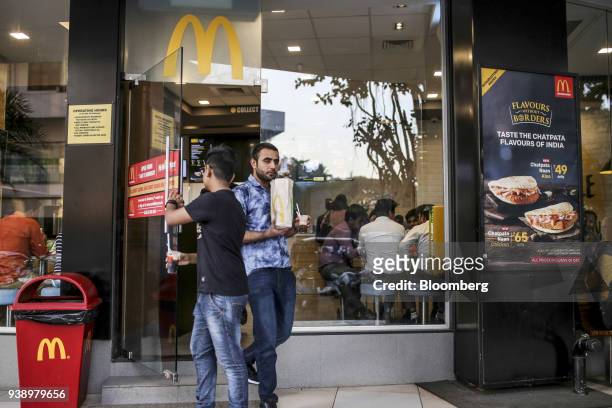 Customers exit a McDonald's Corp. Restaurant, operated by Hardcastle Restaurants Pvt., in Mumbai, India, on Tuesday, March 20, 2018. As the world's...
