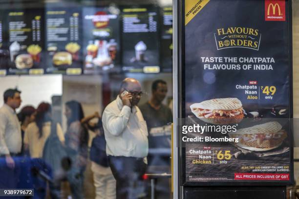 Menu items are displayed in the window of a McDonald's Corp. Restaurant, operated by Hardcastle Restaurants Pvt., in Mumbai, India, on Tuesday, March...