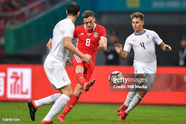 Andy King, center, of Wales national football team kicks the ball to make a pass against players of Uruguay national football team in their final...