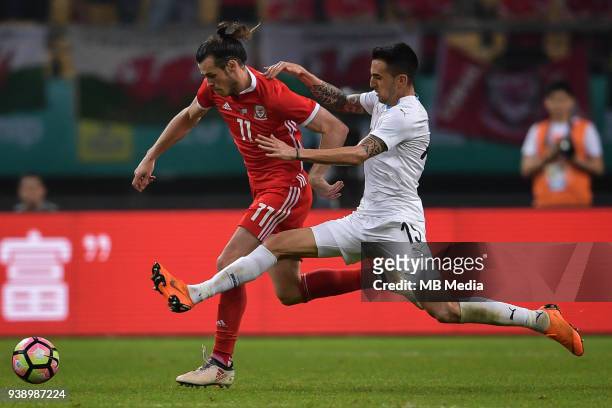 Gareth Bale, left, of Wales national football team kicks the ball to make a pass against Matias Vecino of Uruguay national football team in their...