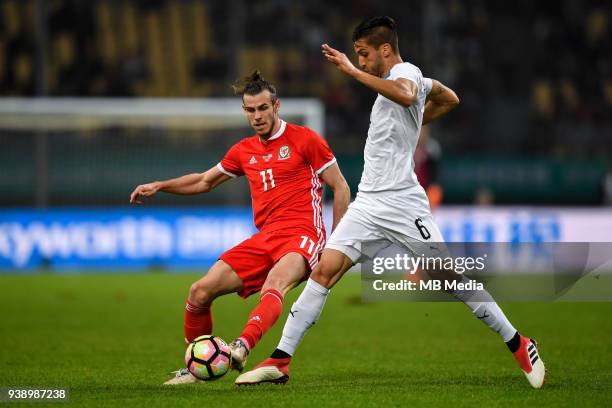 Gareth Bale, left, of Wales national football team kicks the ball to make a pass against Rodrigo Bentancur of Uruguay national football team in their...