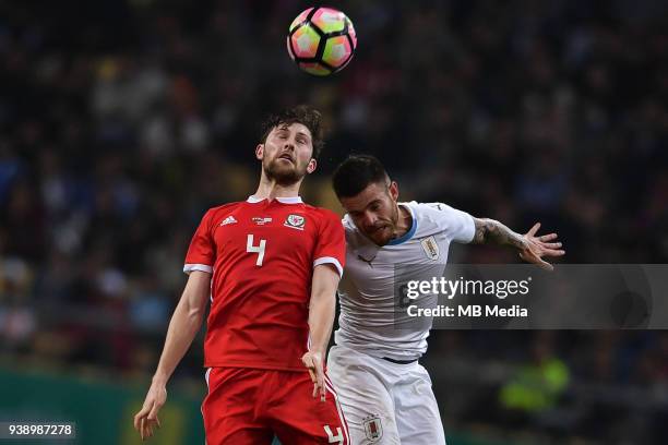 Ben Davies, top, of Wales national football team heads the ball to make a pass against Nahitan Nandez of Uruguay national football team in their...