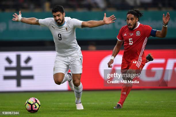 Luis Suarez, left, of Uruguay national football team kicks the ball to make a pass against Ashley Williams of Wales national football team in their...