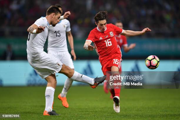 Harry Wilson, right, of Wales national football team kicks the ball to make a pass against players of Uruguay national football team in their final...