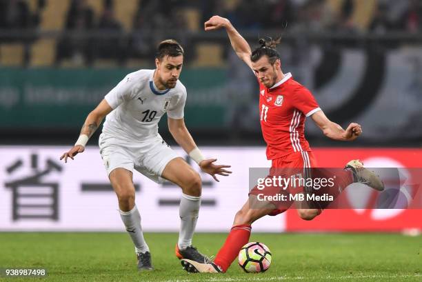 Gareth Bale, right, of Wales national football team kicks the ball to make a shoot against Sebastian Coates of Uruguay national football team in...