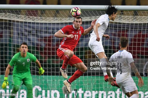 Gareth Bale, second top, of Wales national football team heads the ball to make a pass against Edinson Cavani of Uruguay national football team in...