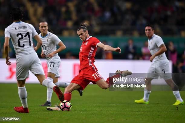 Gareth Bale, center, of Wales national football team kicks the ball to make a shoot against players of Uruguay national football team in their final...