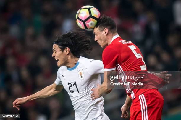 Edinson Cavani, left, of Uruguay national football team heads the ball to make a pass against James Chester of Wales national football team in their...