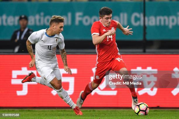 Declan John, right, of Wales national football team kicks the ball to make a pass against Guillermo Varela of Uruguay national football team in their...