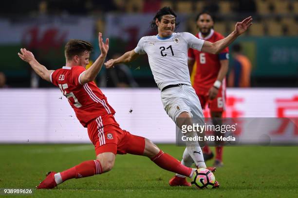 Edinson Cavani, right, of Uruguay national football team kicks the ball to make a pass against Lee Evans of Wales national football team in their...