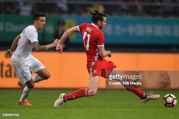 Gareth Bale, right, of Wales national football team kicks the ball to make a pass against a player of Uruguay national football team in their final...