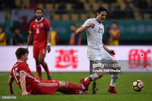 Edinson Cavani, right, of Uruguay national football team kicks the ball to make a pass against a player of Wales national football team in their...