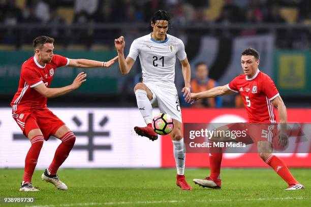 Edinson Cavani, center, of Uruguay national football team kicks the ball to make a pass against players of Wales national football team in their...