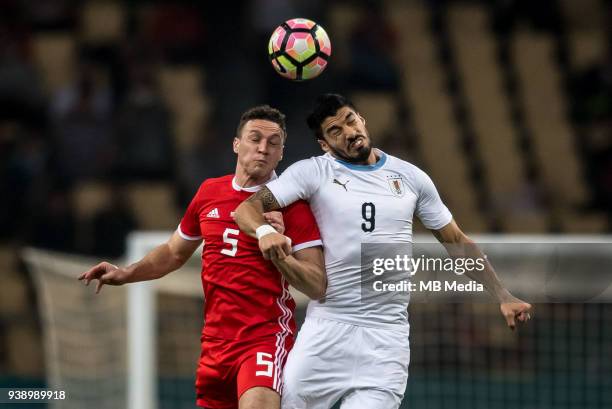 Luis Suarez, right, of Uruguay national football team heads the ball to make a pass against James Chester of Wales national football team in their...