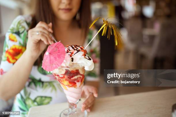 giovane donna incinta che mangia sundae al bar - coppa gelato foto e immagini stock