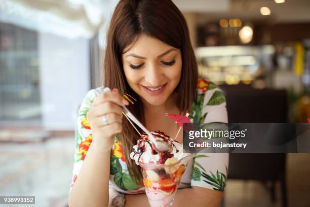jonge zwangere vrouw sundae eten in café - ice cream sundae stockfoto's en -beelden