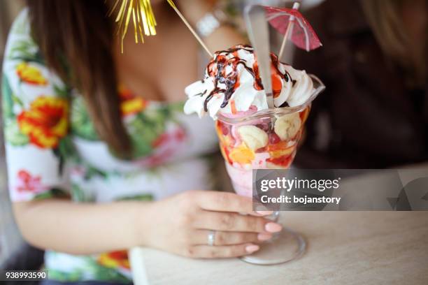 giovane donna incinta che mangia sundae al bar - coppa gelato foto e immagini stock