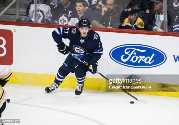 March 27: Winnipeg Jets goalie Connor Hellebuyck looks to make a pass during the NHL game between the Winnipeg Jets and the Boston Bruins on March 27...