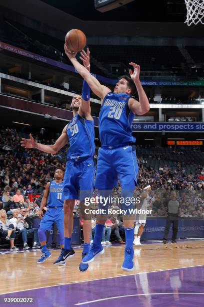 Doug McDermott of the Dallas Mavericks and Salah Mejri of the Dallas Mavericks both reach for the ball during the game against the Sacramento Kings...