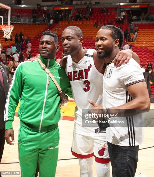Dwyane Wade of the Miami Heat poses for a photo with Antonio Brown and Josh Norman after the game against the Cleveland Cavaliers on March 27, 2018...