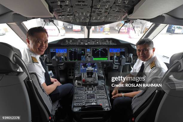 Captain Ian Cheng and Captain Alan Chan Wai Fook pose for a photograph in the cockpit of the Singapore Airlines B787-10 after its arrival from...