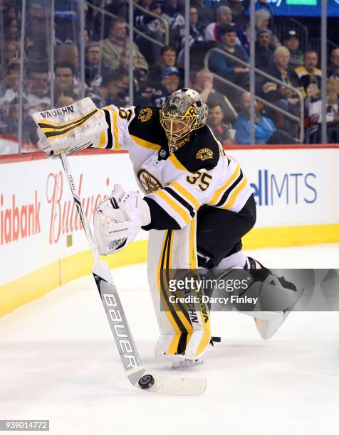 Goaltender Anton Khudobin of the Boston Bruins plays the puck behind the net during first period action against the Winnipeg Jets at the Bell MTS...